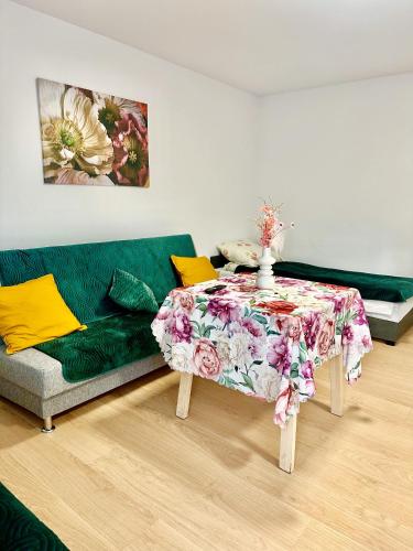 a living room with a green couch and a table at Apartament nr 1 lub 2 przy Sali Kominkowej in Przeczyce
