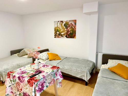 a room with two beds and a table in it at Apartament nr 1 lub 2 przy Sali Kominkowej in Przeczyce