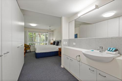 a bathroom with a sink and a bedroom with a bed at Sunshine Vista in Sunshine Beach