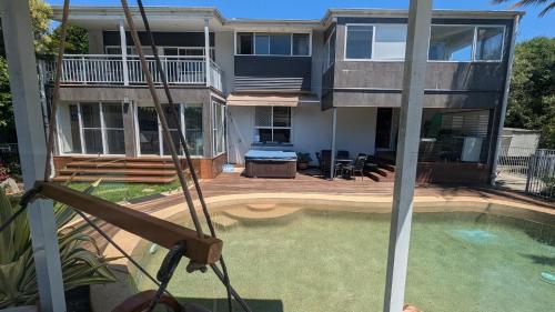 a house with a swimming pool in front of a house at Phoenix Oasis, Family and Pet friendly, with private pool and spa in Port Macquarie