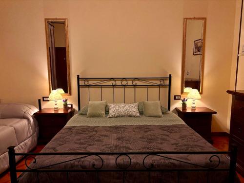 a bedroom with a bed with two lamps and two mirrors at La Strada Di Francesco D'Assisi in Bastia Umbra