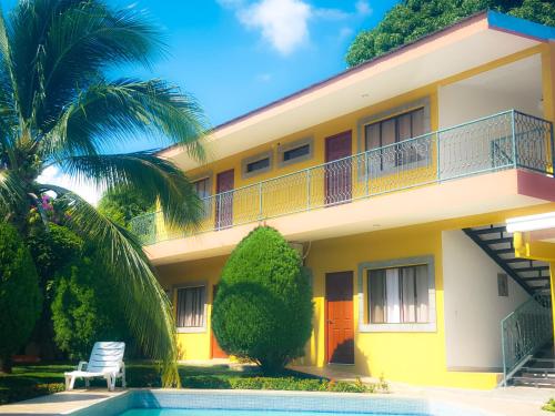 マナグアにあるHotel Los Pinosの正面にプールがある家