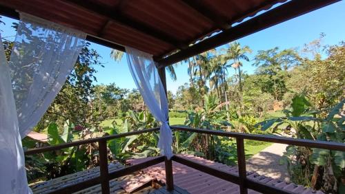 a room with a view of the jungle from a balcony at Pousada e Restaurante Dona Siroba in Morretes