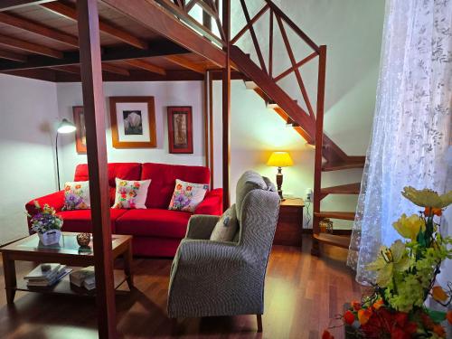 sala de estar con sofá rojo y escalera en Cozy Canarian House La Casa de mis Abuelitos by HRTenerife Net, en Los Silos
