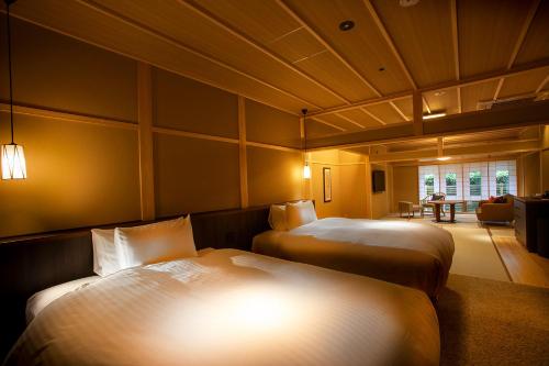 a room with two beds and a living room at Hotel Utano Kyoto Besho in Kyoto