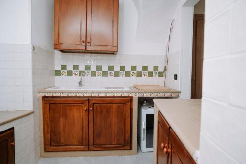a kitchen with wooden cabinets and a sink at Bonne Nuit Terracina in Terracina
