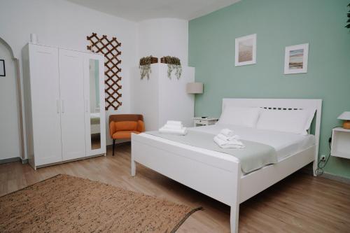 a bedroom with a white bed and an orange chair at Bonne Nuit Terracina in Terracina