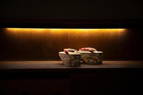 two cups sitting on a shelf in a dark room at Hotel Utano Kyoto Besho in Kyoto