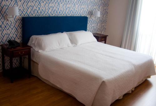 a bedroom with a large bed with a blue headboard at Hotel Central Boutique in Marbella
