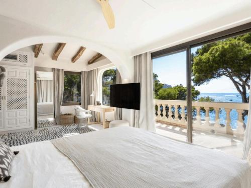 a bedroom with a large white bed and a balcony at Villa in Andratx with Sea Views and Pool in Andratx