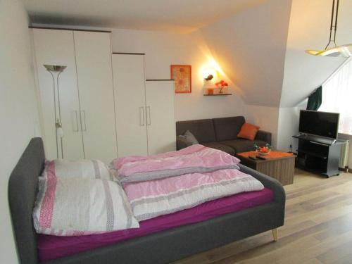 una camera con letto e lenzuola bianche e rosa di in the Kormoran residential complex a Cuxhaven