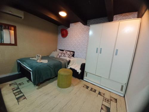 Un dormitorio infantil con una cama y un armario. en Apartamento, Suíte com cozinha, en Penha