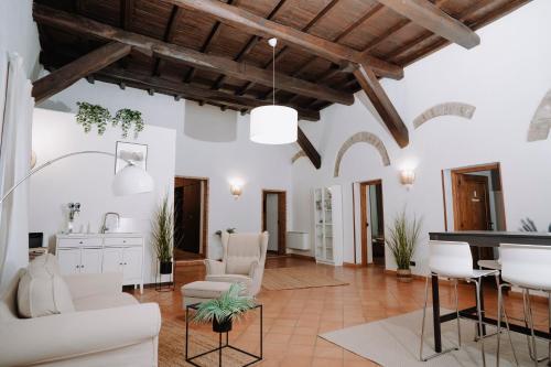 a living room with white furniture and wooden ceilings at Bonne Nuit Terracina in Terracina
