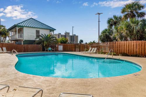 a swimming pool in a yard with chairs and a fence at Wind Drift 114 North by Vacation Homes Collection in Orange Beach