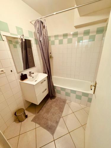 une salle de bain avec un lavabo, une douche et une baignoire dans l'établissement La belle échappée Auxerre Centre, à Auxerre