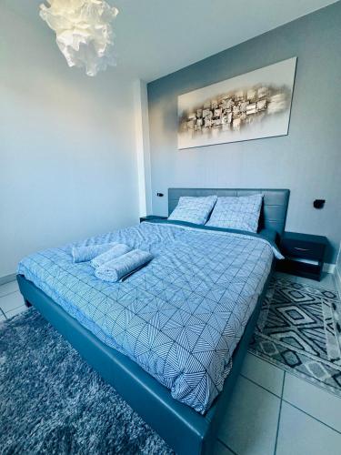 une chambre avec un lit avec une couette bleue dans l'établissement La belle échappée Auxerre Centre, à Auxerre