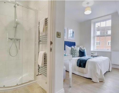 a white bedroom with a bed and a shower at The Byron Suite in Lichfield