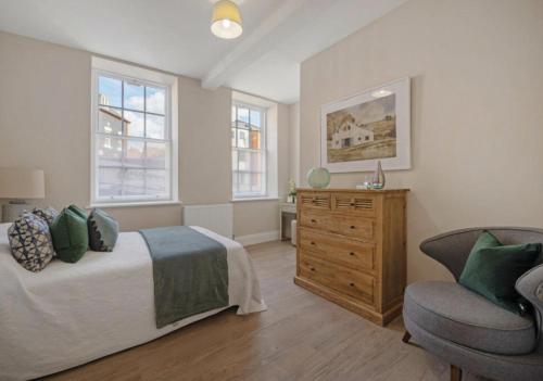 a bedroom with a bed and a dresser and a chair at The Byron Suite in Lichfield