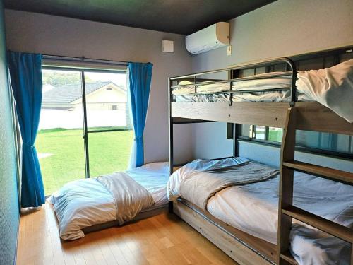 two bunk beds in a room with a window at Shima City Detached house SKO1 in Katada