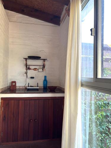 a kitchen with a stove and a window in a room at Monoambiente en Valizas in Barra de Valizas
