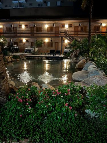 a pond in front of a building at night at Hotel Pousada Santa Rita in Ribeirão Preto