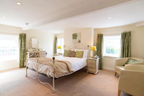 a bedroom with a bed and a couch and a chair at The Treebridge Hotel in Nunthorpe