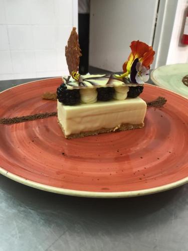 a piece of cake on a red plate on a table at The Treebridge Hotel in Nunthorpe