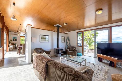 a living room with a couch and a flat screen tv at Welcome on Wilma by Waiheke Pure in Waiheke Island
