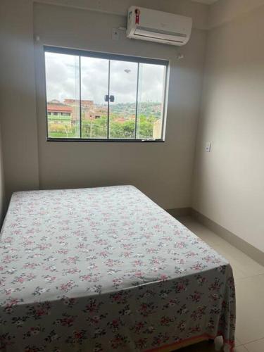 a bedroom with a bed and a window at Apartamento no Centro in Paracatu