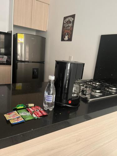 een aanrecht met een koffiezetapparaat en een fles water bij Spacio 202 in Cali