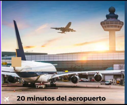 a plane is parked at an airport with a control tower at Klinda Luxury Home Apartament Mi Casa es tu Casa in Mendoza