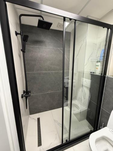 una ducha de cristal en un baño con inodoro en New Modern One bedroom Apartment Julija, en Skopje