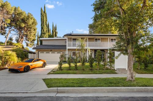 a orange car parked in front of a house at Villa Oasis: Unrivaled Views & Endless Space in Los Angeles
