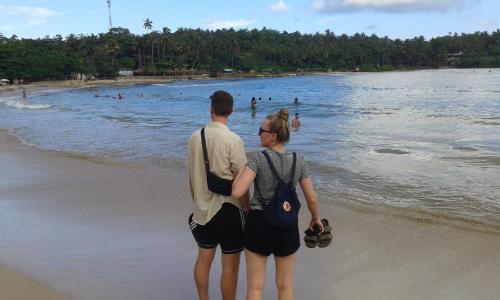 a man and a woman standing on the beach at Coco Mount Residence - Hiriketiya in Dickwella