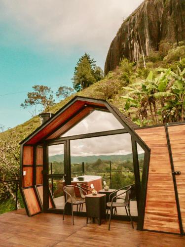 a small cabin with a table and chairs on a deck at La Finca De Frida in Guatapé