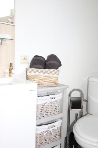 un bagno con cestini su uno scaffale accanto al water di Sandpiper a Ypres