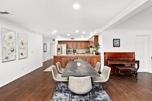a kitchen and dining room with a table and a piano at Villa Oasis: Unrivaled Views & Endless Space in Los Angeles