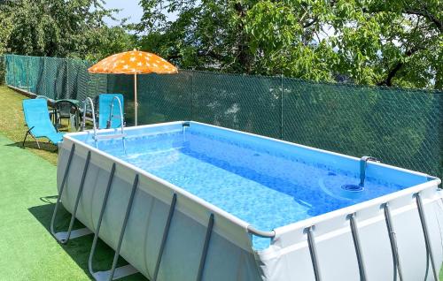 a large swimming pool with an umbrella and an umbrella at Casetta Dei Lupi in Miazzina