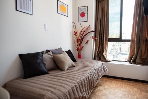 a bed in a room with a large window at El diez 1 dorm con COCHERA in Córdoba