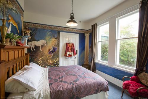 a bedroom with a bed and a painting on the wall at Merrybrook Studio in Oamaru