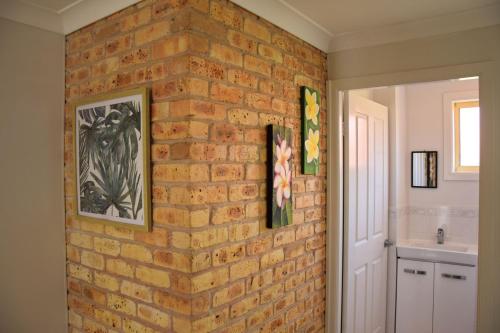 a brick wall in a bathroom with a sink at Ocean Shores 7 South West Rocks - Bring you own linen. in South West Rocks