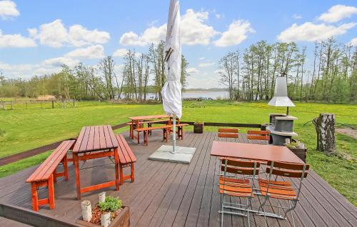 a deck with tables and chairs and an umbrella at Ferienwohnung Südmüritz in Vipperow