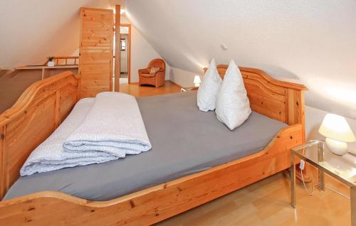 a bedroom with a wooden bed with white pillows at Ferienwohnung Südmüritz in Vipperow