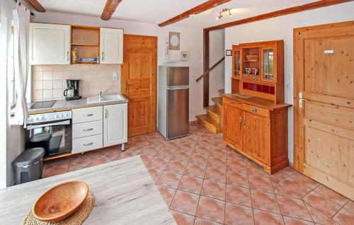 a large kitchen with wooden cabinets and a table at Ferienwohnung Südmüritz in Vipperow