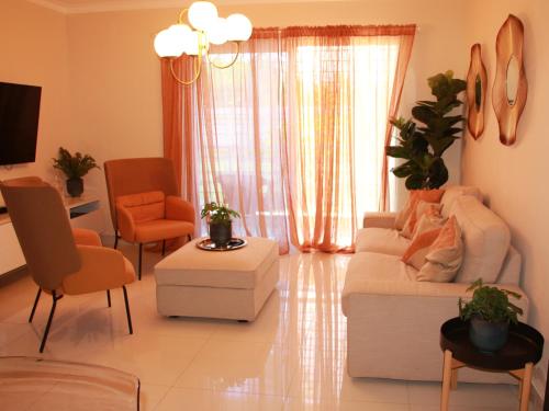 a living room with a white couch and chairs at Las Cayenas Residéncial in Santo Domingo