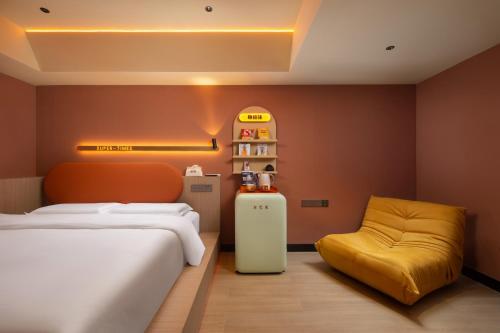 a bedroom with a bed and a yellow chair at Super Time Trendy Design Hotel Guangzhou Beijing Road Pedestrian Street Dafo Temple Branch in Guangzhou