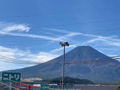 a mountain in the distance with a street light at ロッソ富士 in Fujiyoshida