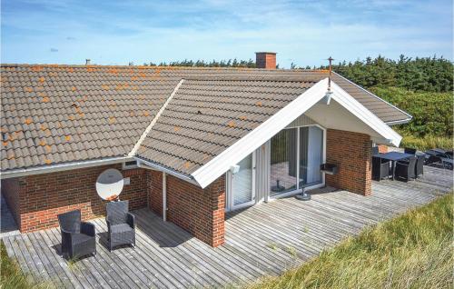 una casa con una terraza de madera con sillas en Pet Friendly Home In Hvide Sande, en Hvide Sande