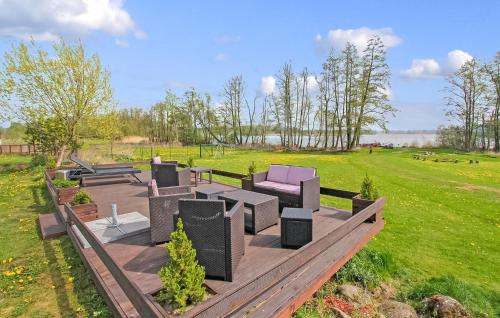 a deck with chairs and tables in a field at Ferienwohnung Südmüritz in Vipperow
