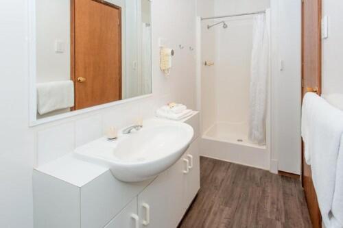 Un baño blanco con lavabo y espejo. en BIG4 Melbourne Holiday Park, en Melbourne